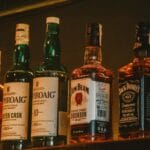 Butelki premium whisky na podświetlonej, przyciemnionej półce