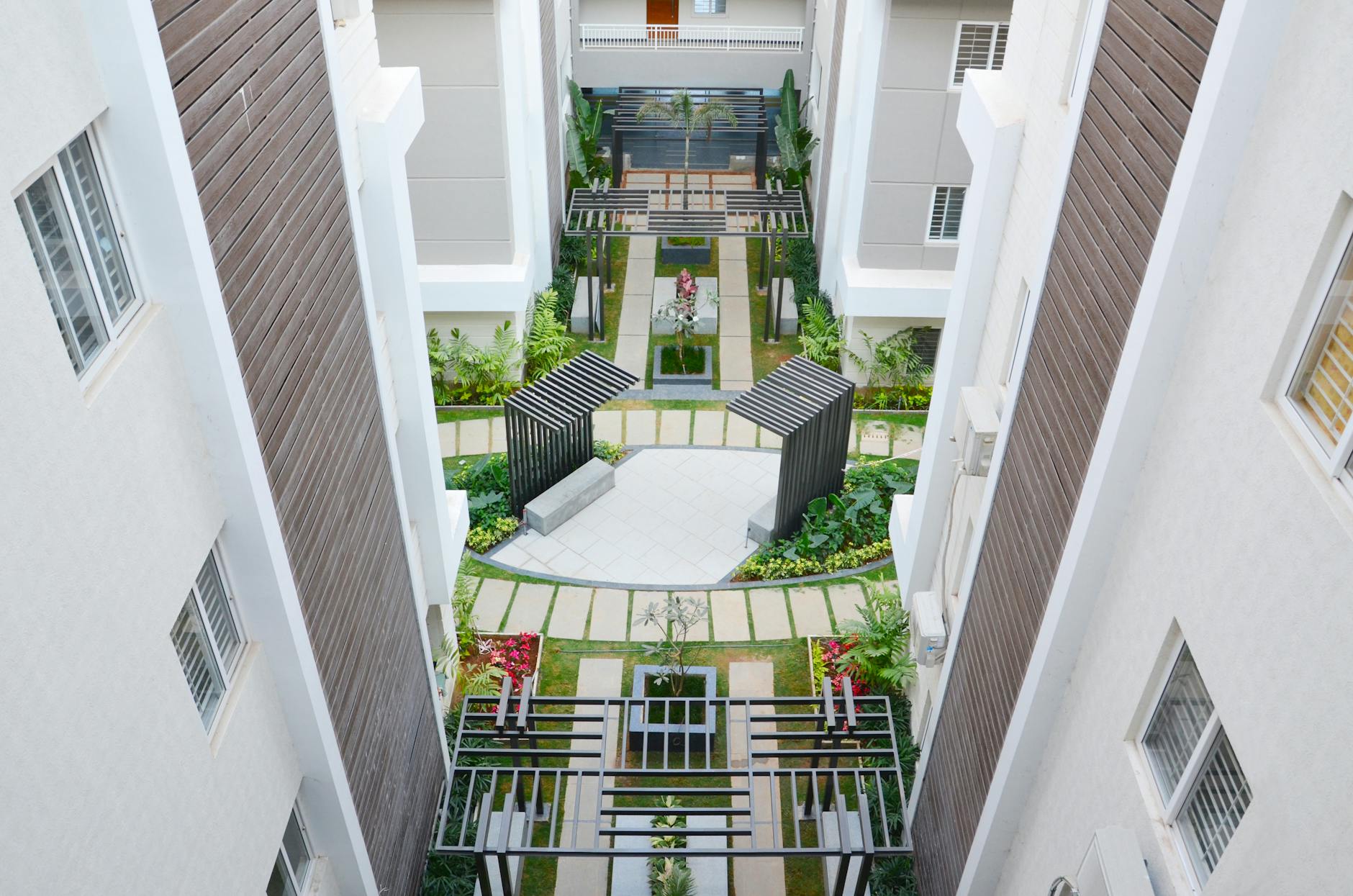 Dziedziniec apartamentowca z bujną zielenią widziany z lotu ptaka