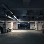 Ciemny parking podziemny z zaparkowanymi samochodami i słabym oświetleniem