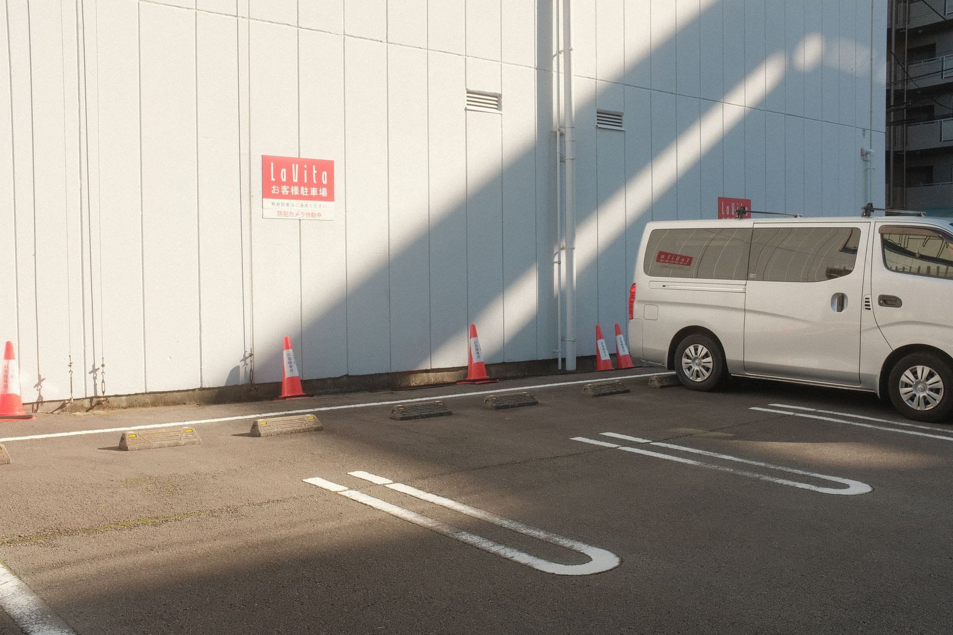 Pusty miejski parking z białym vanem w słońcu i cieniu